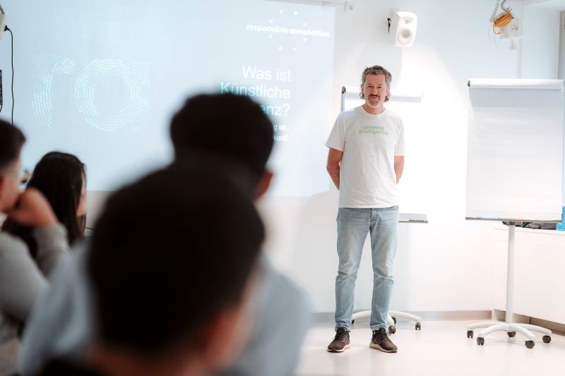 Bernhard Schenkenfelder als Vortragender des Workshops "Was ist KI". Im Vordergrund sieht man zuhörende Jugendliche.